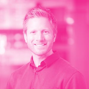 Benji Sucher's headshot with a hot pink filter.